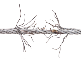 Corroded-frayed-cable.jpg-e1583693353504 Na zdjęciu widać zużyty stalowy kabel z wieloma rozplątującymi się pasmami, wyraźnie widoczny na białym tle. Ta ilustracja jest prezentowana na stronie internetowej specjalizującej się w naprawie bram, rolet i barier w Warszawie.